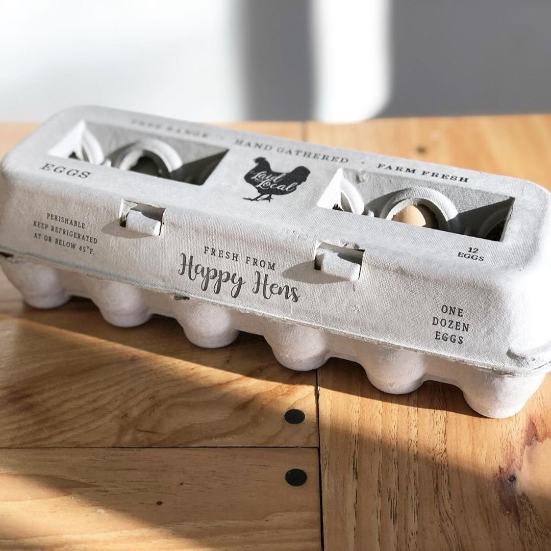 Egg carton labeled 'Happy Hens' on a wooden surface