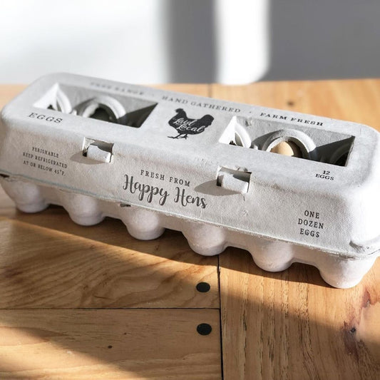 Egg carton labeled 'Happy Hens' on a wooden surface