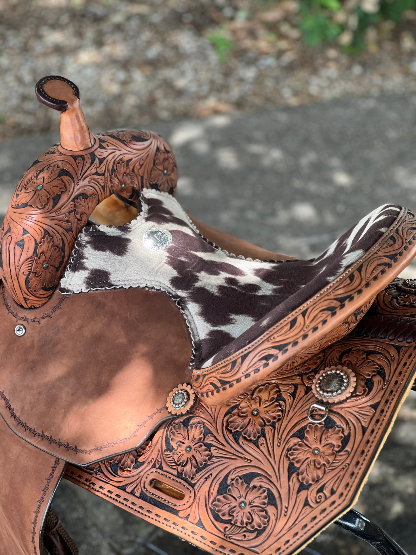 Close-up of a brown leather saddle with intricate patterns on a blurred background